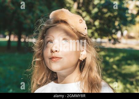 Mädchen mit einem Hamster in der Natur. Fröhliche glücklich Kind Mädchen mit Haustier Hamster spielt im Garten des Hauses im Sommer. Liebe, Fürsorge, Zärtlichkeit Konzept. Hochwertige Fotos Stockfoto