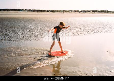 Skim Boarding in West Wittering Beach, Chichester, West Sussex, England, Vereinigtes Königreich, England, Vereinigtes Königreich. Stockfoto