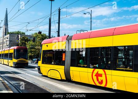 Warschau, Polen - 1. September 2018: Zwei gelbe Straßenbahnen verkehren in Warschau, Polen, mit Passagieren Stockfoto