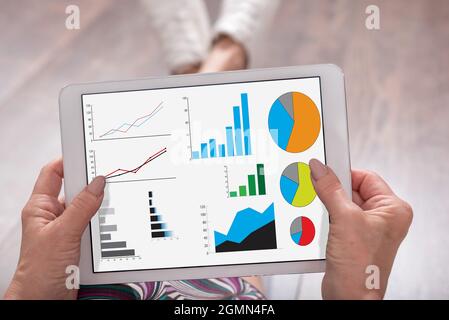 Grafisches Analysekonzept, das auf einem Tablet dargestellt wird, das von einer Frau gehalten wird Stockfoto