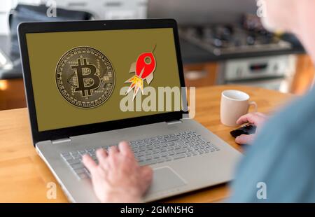 Mann, der einen Laptop mit Bitcoin-Wachstumskonzept auf dem Bildschirm verwendet Stockfoto