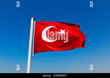 Türkische Flagge gegen blauen Himmel Stockfoto