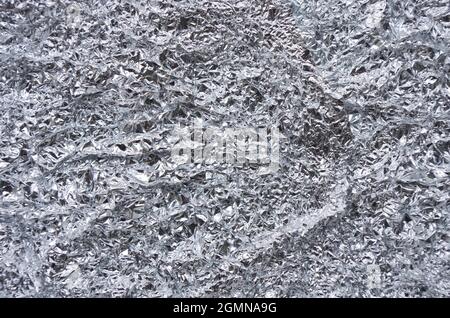 Zerknitterte Aluminiumfolie Textur Nahaufnahme Hintergrund. Aluminium. Silberne Aluminiumfolie mit glänzendem zerknittert von Aluminiumpapier Hintergrund. Stockfoto