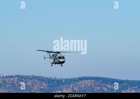 Der von Hindustan Aeronautics Limited entwickelte fortschrittliche leichte Hubschrauber Dhruv fliegt vor dem Hintergrund eines klaren blauen Himmels. Stockfoto