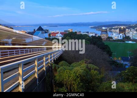 Blick auf Wellington, Neuseeland, in der Dämmerung, vom Kelburn Aussichtspunkt. Im Vordergrund sind leichte Wege der berühmten Wellington Cable Car zu sehen Stockfoto