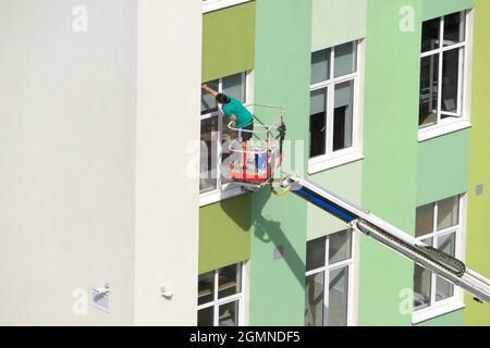 Nischni Nowgorod, Russland, Gagarin Avenue 101 b, Schule Nr. 34. 08.26.2021. Eine Frau, Angestellte einer Reinigungsfirma, wäscht die Fenster des Gebäudes Stockfoto