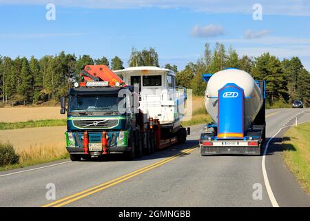 Grüner Volvo FM Sattelanhänger transportiert Freizeitboot als Übergröße Last, Tankwagen fährt in entgegengesetzte Richtung. Salo, Finnland. 9. September 2021 Stockfoto