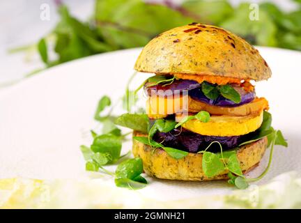 Frischer und gesunder Burger auf pflanzlicher Basis auf einem pflanzenbasierten Brötchen mit Erbsensprossen Stockfoto