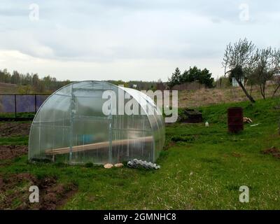 Gewächshaus aus Polycorbanat im Garten, im Frühjahr Stockfoto