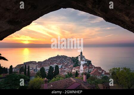 Atemberaubende Aussicht auf den Sonnenuntergang von der stadtmauer piran Piransko obzidje durch Wand Fensterbogen . Stockfoto