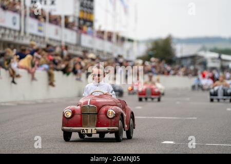 Esme Graham lächelt, als sie die Linie auf dem ersten Platz überquert, weit vor dem Rest der Autos, gewinnt sie den Settrington Cup in ihrem roten Vintage Austin J40 Pedalwagen mit der Nummer 41. Ein nostalgisches Rennen für Kinder beim ausverkauften Vintage Goodwood Revival Event 2021. Kredit: Sarnia/Alamy Live Nachrichten Stockfoto