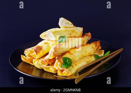 Blintz, gerollt gefüllt mit gesüßten Quark-Pfannkuchen oder Crepes auf einem Teller Stockfoto