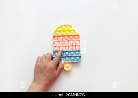 Eis Pop it Fidget Spielzeug Antistress für Kinder und Erwachsene auf grauem Hintergrund Stockfoto