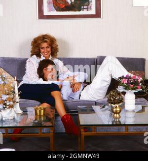 Bernd Clüver, deutscher Schlagersänger, fehlerhaft mit Ehefrau Ute Kittelberger auf dem Sofa im Wohnzimmer in Mannheim, Deutschland um 1982. Der deutsche Schlagersänger Bernd Cluever ist um 1982 mit seiner Frau Ute Kittelberger auf dem Sofa im Wohnzimmer ihres Hauses in Mannheim, Deutschland, faul. Stockfoto