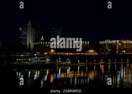 Die Altstadt von Sacramento bei Nacht in der Nähe von Weihnachten, von der anderen Seite des Sacramento River aus gesehen, mit Weihnachtslichtern, die sich am 2020. Dezember auf dem Fluss spiegeln Stockfoto