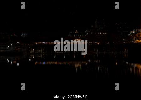 Die Altstadt von Sacramento bei Nacht in der Nähe von Weihnachten, von der anderen Seite des Sacramento River aus gesehen, mit Weihnachtslichtern, die sich am 2020. Dezember auf dem Fluss spiegeln Stockfoto