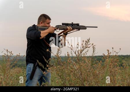 Europäer schießt ein Gewehr mit einem optischen Blick. Porträt eines Schützen mit einem Gewehr Stockfoto