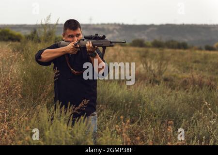 Porträt eines Schützen mit einem Gewehr. Europäer schießt ein Gewehr mit einem optischen Blick Stockfoto