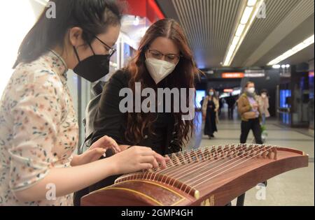 Wien. September 2021. GU Jianing (L), ein Student der Jacquingasse Music School, stellt Guzheng, ein traditionelles chinesisches Musikinstrument, einem lokalen Volkstheater-Sender in Wien, Österreich, Spet vor. 20, 2021. Die Veranstaltung mit traditionellen chinesischen Musikinstrumenten findet im Rahmen eines Kulturfestivals statt, das das chinesische Mid-Autumn Festival feiert. Kredit: Guo Chen/Xinhua/Alamy Live Nachrichten Stockfoto