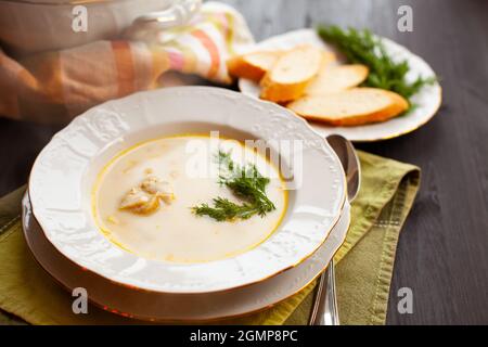 Cremige Fischsuppe mit Lachs, Kartoffeln und Dill auf dunklem Holztisch, Nahaufnahme Stockfoto