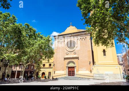 Barcelona, Spanien - 7. Juli 2017: Tagesansicht von Plaça de la Concòrdia und Església de Santa Maria del Remei mit Einheimischen auf Bänken in Barcelona, Spanien. Stockfoto