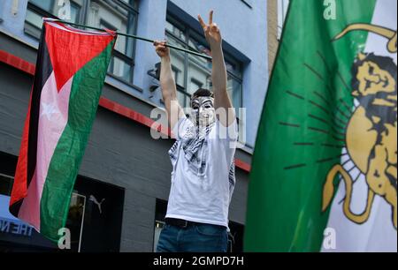 Ein Protestor, der während der Demonstration eine Guy Fawkes-Maske mit einer palästinensischen Flagge trug. Stockfoto