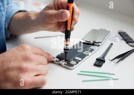Nahaufnahme Des Menschen, Der Versucht, Das Mobiltelefon Zu Reparieren, Anstatt Neue Produkte Zu Kaufen, Nachhaltiger Lebensstil Stockfoto