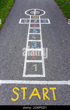 Eine gezeichnete Figur für ein Kinderspiel - hopscotch auf einer asphaltierten Straße Stockfoto