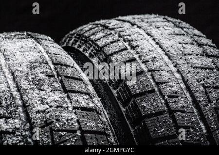 Winter Car Reifen mit Schnee Nahaufnahme Radprofil Struktur auf schwarzem Hintergrund. Stockfoto