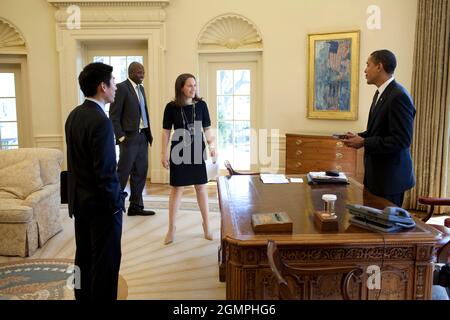 Präsident Barack Obama scherzt mit dem Sonderassistenten Eugene Kang, der persönlichen Sekretärin Katie, Johnson und der persönlichen Aide Reggie Love im Oval Office 3/5/09. Offizielles weißes Haus Foto von Pete Souza Stockfoto