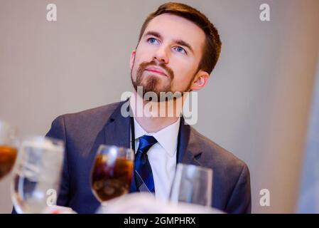 Schöner Mann mit dunklen Haaren und Ziegenbart, der aufmerksam aufschaut Stockfoto