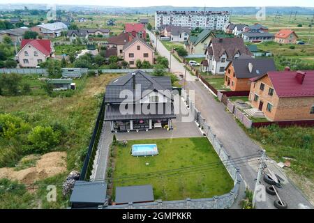 Luftaufnahme des privaten Hauses mit grünem Hinterhof und kleinem Schwimmbad auf Rasen. Stockfoto