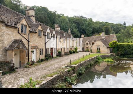 Die malerischen traditionellen Steinhütten neben der Brook River Bridge im unberührten Cotswold Village Castle Combe, Wiltshire, England, Großbritannien Stockfoto