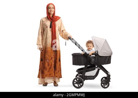 In voller Länge Porträt einer Frau, die einen Hijab trägt und ein Baby in einem Kinderwagen auf weißem Hintergrund läuft Stockfoto