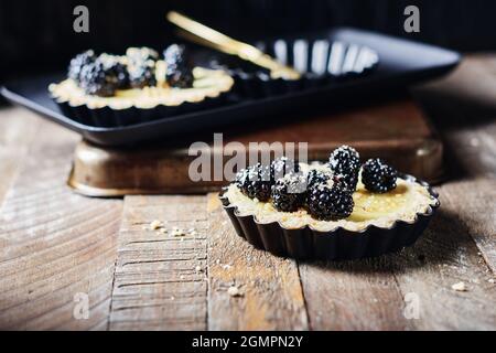 Frisch gebackene Brombeeren- und Vanillepudding-Torten. Stockfoto