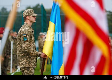 REGION LVIV, UKRAINE - 20. SEPTEMBER 2021 - Ein Soldat hält die Nationalflagge der Ukraine während der ukrainisch-amerikanischen Militärübungen RAPID TRIDENT - 2021 auf dem Gelände des Internationalen Zentrums für Friedenssicherung und Sicherheit der Nationalen Akademie der Landstreitkräfte benannt nach Hetman Petro Sahaidachnyi, Region Lviv, western Ukraine Kredit: Ukrinform/Alamy Live Nachrichten Stockfoto