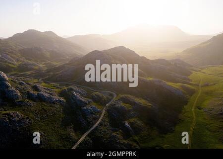 Luftaufnahme einer Straße vom Lukavica-Plateau zum Kapetanovo-See, Captain's Lake bei Sonnenuntergang in den Omountains hoch über Niksic, Montenegro Stockfoto