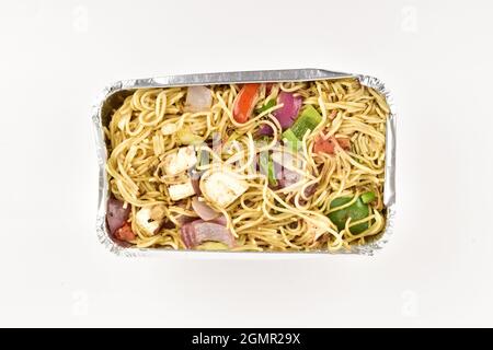 Draufsicht auf Veg Hakka Nudeln in Folienbehälter isoliert auf weißem Hintergrund mit Beschneidungspfad Stockfoto
