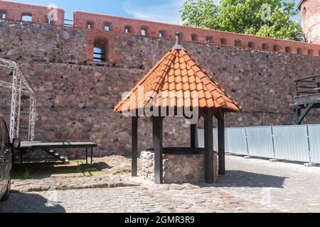 Brunnen auf dem Innenhof des Schlosses der gotischen deutschen Burg und eine ehemalige Festung für pommersche Herzöge in Bytow, Polen. Stockfoto