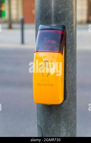 Taste für Ampel für Fußgänger. Touch-Taste mit Text bitte in deutscher Sprache berühren. Stockfoto