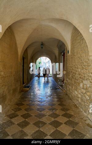 Touristen an einem Durchgang in der Kathedrale des Hl. Quirinus in der Altstadt von Krk in Kroatien Stockfoto