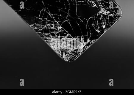 Nahaufnahme von zerschmetterten Bildschirm Smartphone auf dunklem Hintergrund, zerbrochenen Bildschirm Smartphone Stockfoto