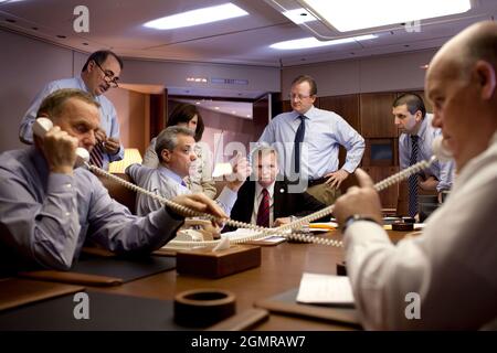 Der nationale Sicherheitsberater, General James Jones, Left, und der für die USSS zuständigen Sonderbeauftragten Joe Clancy koordinieren die Ankunftsdetails telefonisch für den Besuch von Präsident Barack Obama in Bagdad am 7. April 2009. David Axelrod, Senior Advisor des Weißen Hauses, Rahm Emanuel, Jim Messina, stellvertretender Stabschef, Robert Gibbs, Pressesprecher des Weißen Hauses und Mark Lippert, Chief of Staff des National Security Counsel, im Hintergrund rechts, kamen ebenfalls dazu. Offizielles weißes Haus Foto von Pete Souza Stockfoto