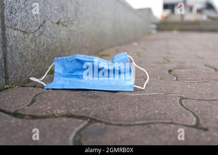 Weggeworfener Mund-Nase-Schutz auf einem Weg im Zentrum von Berlin in deutschland Stockfoto