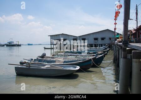fisher boats am Ozean mit Holzhäusern im Hintergrund in penang malaysia Stockfoto
