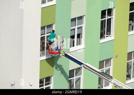 Nischni Nowgorod, Russland, Gagarin Avenue 101 b, Schule Nr. 34. 08.26.2021. Eine Frau, Angestellte einer Reinigungsfirma, wäscht die Fenster des Gebäudes Stockfoto