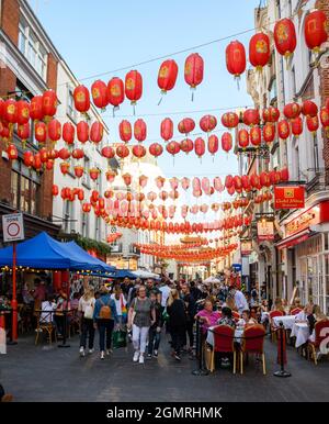 London, Vereinigtes Königreich - 10 2021. August: Scharen von Einkäufern und Gasthäusern im Viertel Chinatown, die mit Laternen entlang der Rupert Street gespeist sind Stockfoto