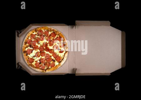 Leckere Paperoni Pizza in offener Box isoliert auf schwarzem Hintergrund. Blick von oben auf Paperoni Pizza. Konzept für italienisches Essen, Street Food, Fast Food, schnell Stockfoto