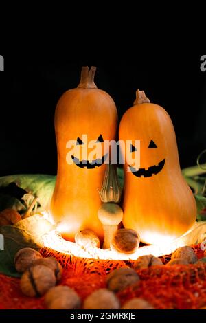 Zwei Halloween Kürbisse auf schwarzem Hintergrund im Licht Stockfoto