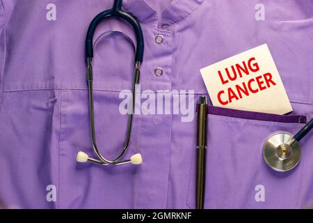 Symbol für Lungenkrebs. Medizinische Uniform, weiße Karte mit den Worten Lungenkrebs, Metallstift und Stethoskop. Medizinisches und Lungenkrebskonzept. Stockfoto